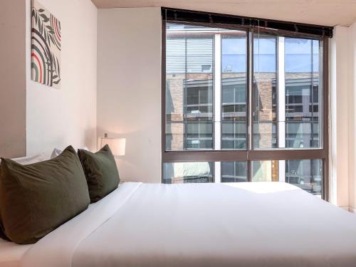 a bedroom with a large white bed and a large window at City & River View Suite - The Wharf DC by Monthier in Washington