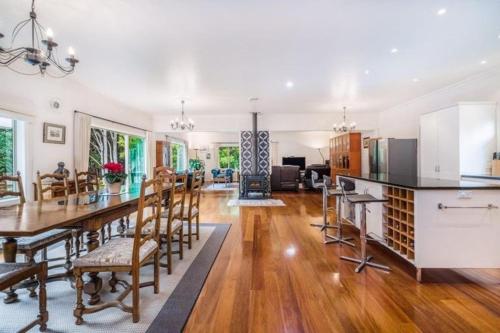 a kitchen and living room with a table and chairs at NZ County Holiday Home in Kamo