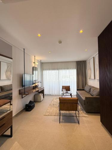 a large living room with a couch and a tv at Caesar Premier Eilat Hotel in Eilat