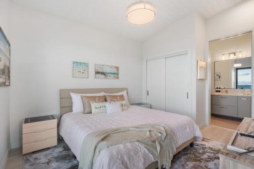a bedroom with a large bed and a bathroom at Beachfront Villa #14 at The Beach House in Campbell River