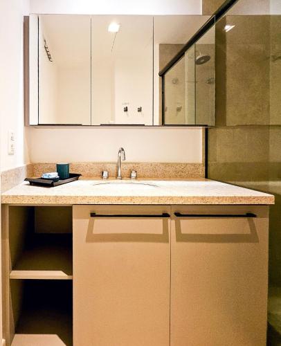 a kitchen with a sink and a large mirror at JP Redenção by LikeHome in Porto Alegre