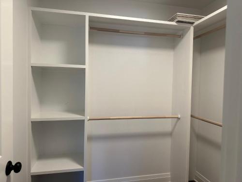 a white walk in closet with white shelves at Vacation home in Riverhead