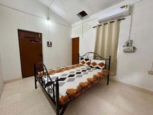 un piccolo letto in una stanza con una finestra di 2BHK - Jzee Homestays - 12 minute walk to the beach a Benaulim