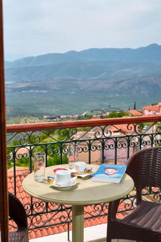 a table and chairs on a balcony with a view at Fedriades Delphi Hotel in Delfoi