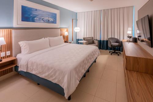 a hotel room with a large bed and a desk at Holiday Inn Acapulco La Isla by IHG in Acapulco