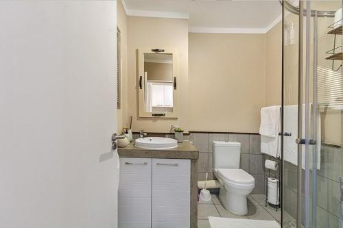 Un baño blanco con inodoro y lavabo. en The Paddocks Pearl -115, en Fourways