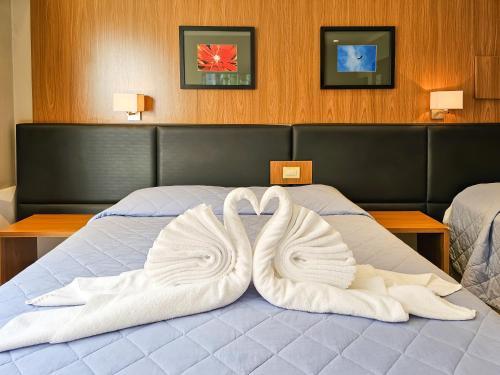 two swans towels are made to look like swans on a bed at VOA Hotel Paraíso das Águas Bonito in Bonito