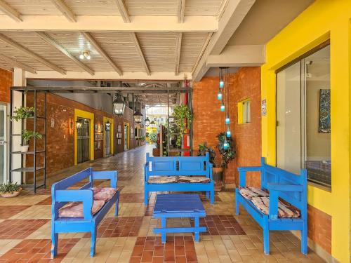 a hallway with blue chairs in a building at VOA Hotel Paraíso das Águas Bonito in Bonito