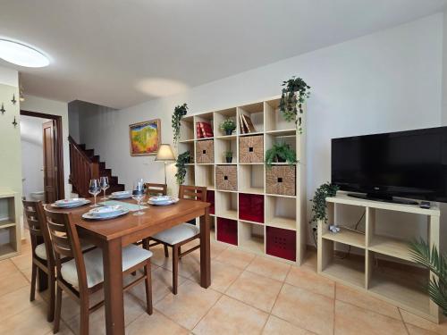 a dining room with a table and a tv at ADOSADO FAMILIAR - PRELLEZO - Gupo RH 5 in Prellezo