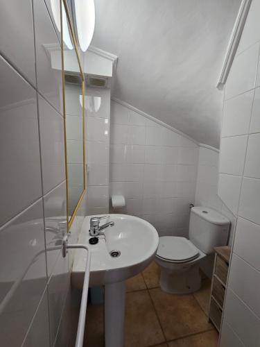 a white bathroom with a sink and a toilet at ADOSADO FAMILIAR - PRELLEZO - Gupo RH 5 in Prellezo