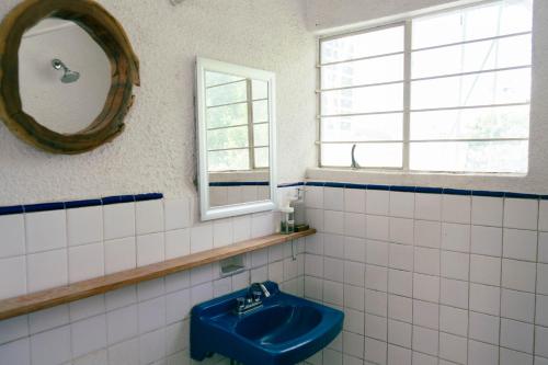 a bathroom with a blue sink and a mirror at Casa Sabina in Guadalajara