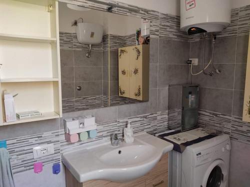 Un baño con lavabo y lavadora. en Villa Rosalba, en Villasimius
