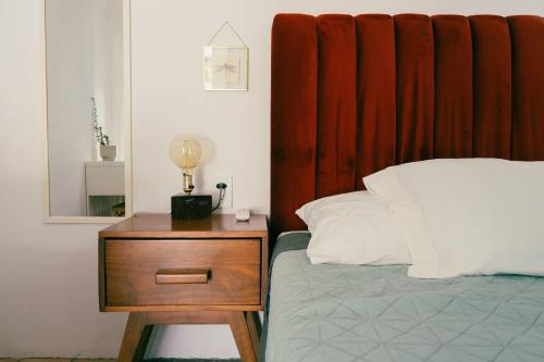 a bed with a wooden headboard and a wooden nightstand with a nightstand at Casa Sabina in Guadalajara