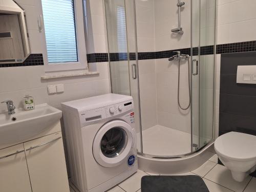 bagno con lavatrice e doccia di Apartament Platynowy - Malbork a Malbork