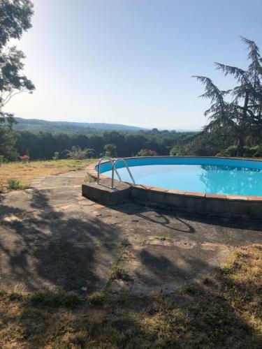 an empty swimming pool in a field next to a tree at Mobil home 2ch in Damiatte