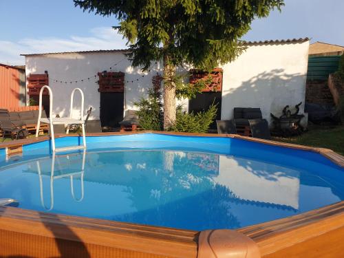 una piscina con una silla en un patio en CASA TURÍSTICA Villa Carmen, CON AMPLIO JARDIN QUE INCLUYE BARBACOA, 2 PORCHES, PARKING PRIVADO Y PISCINA, en Arenzana de Abajo