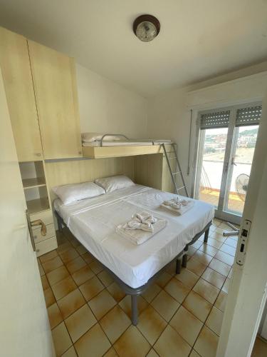 małą sypialnię z łóżkiem i półką w obiekcie Suitevoluto w mieście Scalea