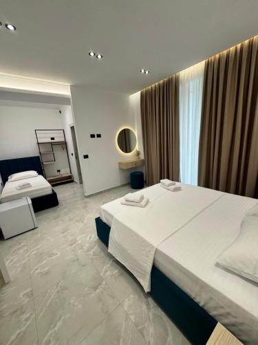 a large hotel room with two beds and a window at Villa e Diellit in Kaninë