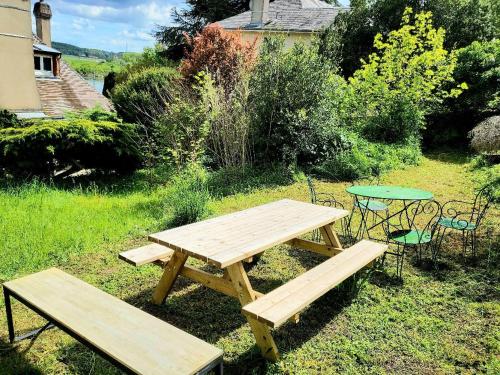 - une table de pique-nique en bois et un banc dans la cour dans l'établissement Appart 10personnes Jardin Parkings Voitures Vélos,10min Centre Blois,40min Zoo Beauval, à Blois