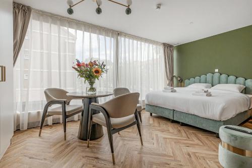 Un dormitorio con una cama y una mesa con sillas. en Bens The Walton, en Ámsterdam