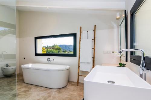 a bathroom with a large white tub and a window at Hort Petit de Ternelles in Pollença