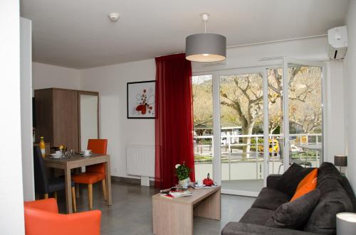 un salon avec un canapé et une table dans l'établissement Résidence Ambroise Paré, à Lamalou-les-Bains