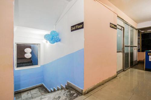 a hallway with a exit sign and blue balloons at Hotel O River View in Patna
