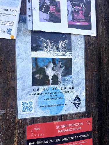 a sign on a wooden pole with posters on it at AL Cosy in Vars Ski & Nature in Vars