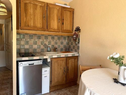 a kitchen with wooden cabinets and a white dishwasher at AL Cosy in Vars Ski & Nature in Vars