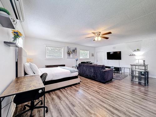 a bedroom with a bed and a couch and a tv at Comfy Studio Farm Stay in Orlando