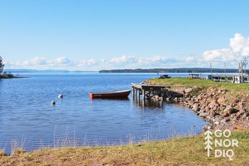 a lake with a dock and a boat in the water at The Lazy Moose in Tällberg