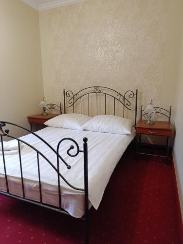 a bedroom with a bed with two nightstands and two tables at Villa Roma in Miedzierza