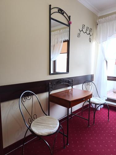 a room with a table and two chairs and a mirror at Villa Roma in Miedzierza