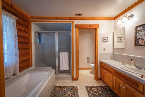 a bathroom with a tub and a shower and a sink at Oakwood Lodge in Nipomo