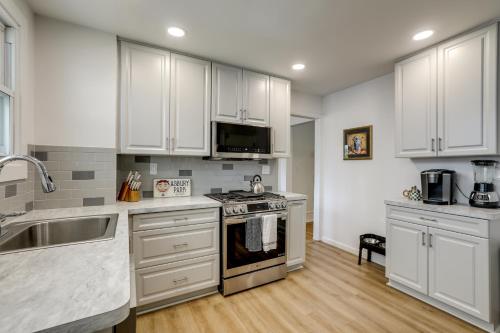 a kitchen with white cabinets and a stove top oven at 1 Mi to Beaches and Boardwalk Asbury Park Retreat in Asbury Park