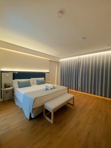 a large bedroom with a large bed and a bench at Hotel Boutique La Brisa del Mar in Estepona