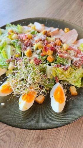 a plate of eggs and salad on a table at Warsoliv double in Warsaw