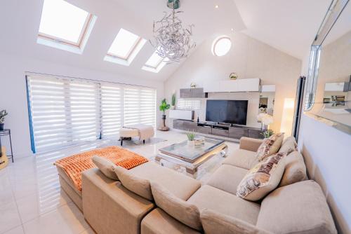 a living room with a couch and a tv at Spacious 7 Bedroom 5 Bathroom Mansion with Parking in Cardiff