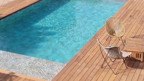 - deux chaises assises sur une terrasse à côté d'une piscine dans l'établissement Ventoux Ride & Chill, à Carpentras