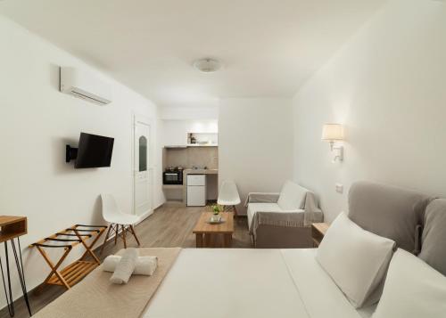 a white room with a bed and a living room at DK Square in Andros