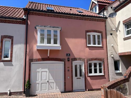 a red and white house with a garage at Poppyline Mews in Sheringham