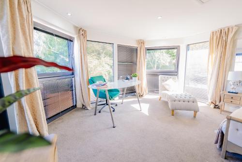 a room with a table and chairs and windows at Spacious 7 Bedroom 5 Bathroom Mansion with Parking in Cardiff