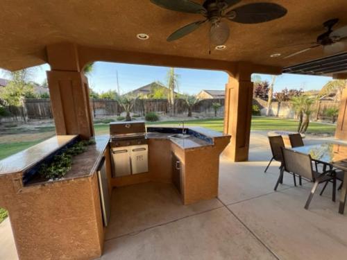 an outdoor kitchen with a ceiling fan and a patio at Cadbury 4BR Outdoor Kitchen Sleeps 8 Peaceful in Bakersfield