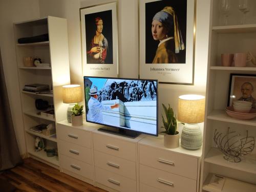 a tv sitting on a dresser in a room with pictures at Nowoczesne lokum w Centrum in Częstochowa
