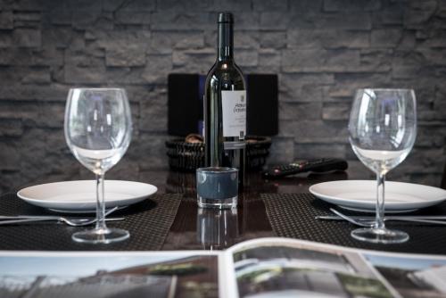 a table with two wine glasses and a bottle of wine at Triumph Inn Pension in Rangsdorf