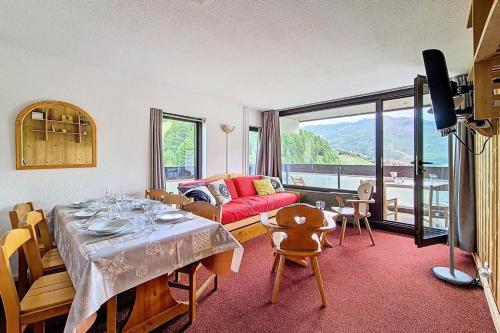 un salon avec une table et un canapé dans l'établissement Résidence Dorons - Appartement agréable · Accès direct aux pistes · Balcon MAE-2204, aux Menuires