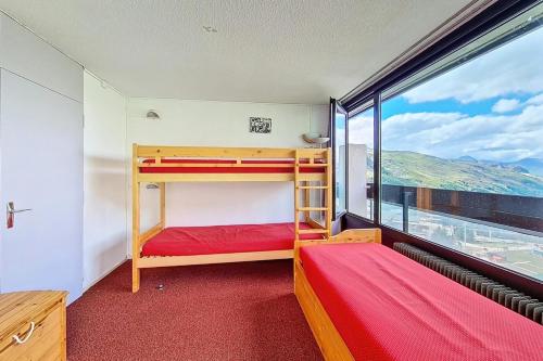 deux lits superposés dans une chambre avec une grande fenêtre dans l'établissement Résidence Dorons - Appartement agréable · Accès direct aux pistes · Balcon MAE-2204, aux Menuires