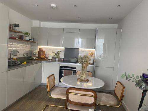 Una cocina con una mesa y sillas en una cocina. en London Penthouse Apartment with stunning views, en Moffat