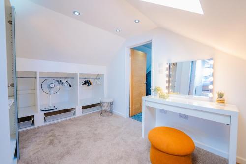a bathroom with an orange chair and a mirror at Spacious 7 Bedroom 5 Bathroom Mansion with Parking in Cardiff