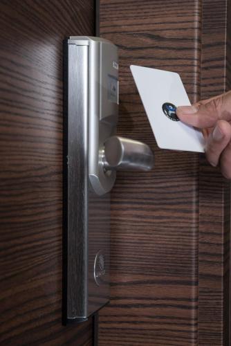 a person putting a piece of paper into a door at Triumph Inn Pension in Rangsdorf